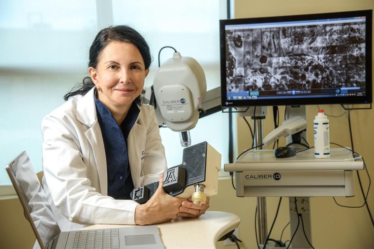 Dr. Curiel-Lewandrowski smiling next to medical equipment.