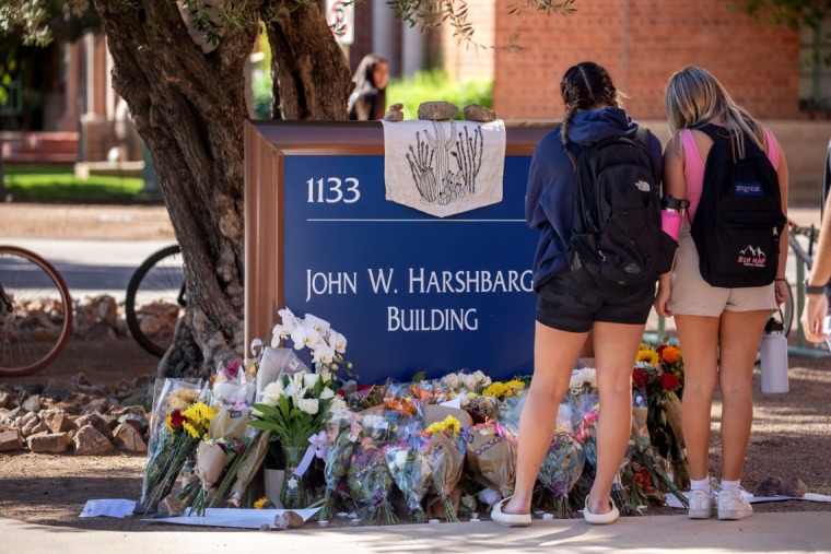 Students visit a makeshift memorial outside the John W. Harshbarger Building.