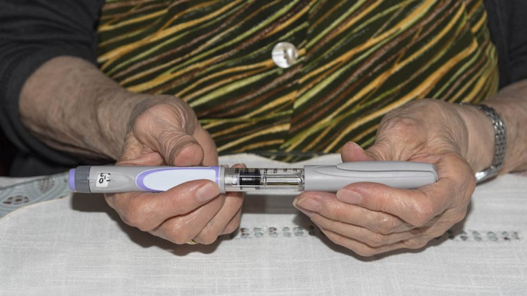 A women hold an injection pen.