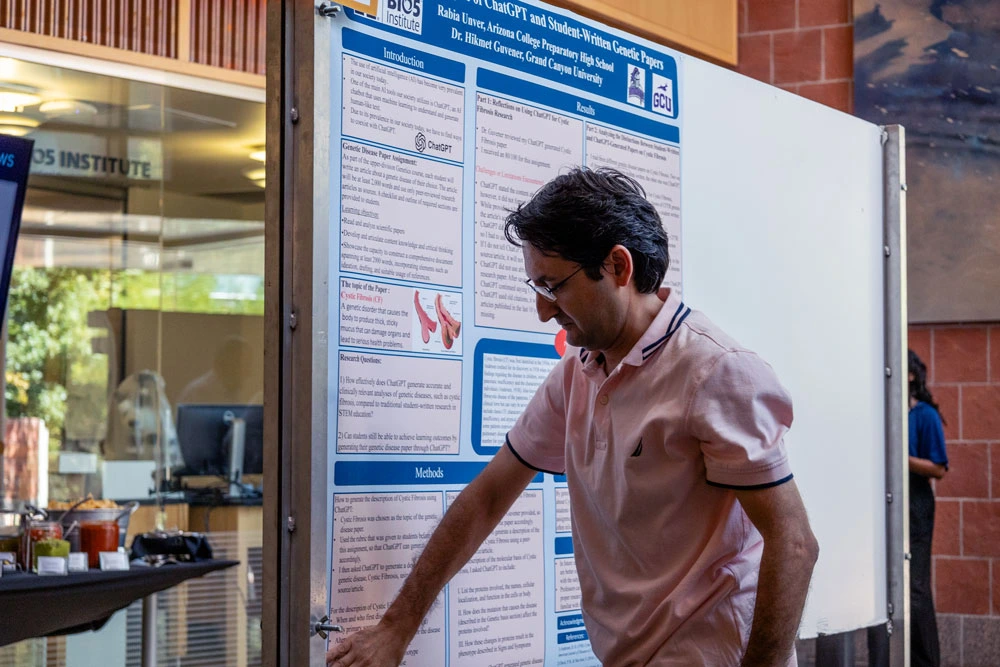 Person presenting a scientific poster at the BIO5 Institute. The poster includes diagrams and text related to technology healthcare research.