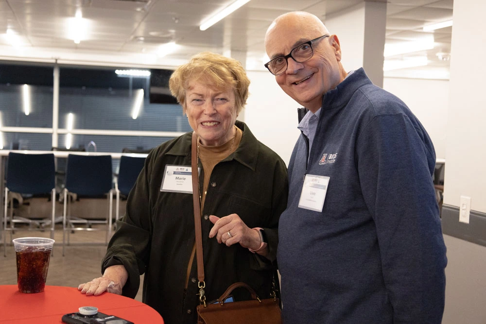 Two individuals, Marie Wesselhoft and Uwe Hilgert, smiling at a networking event with beverages on a red table.