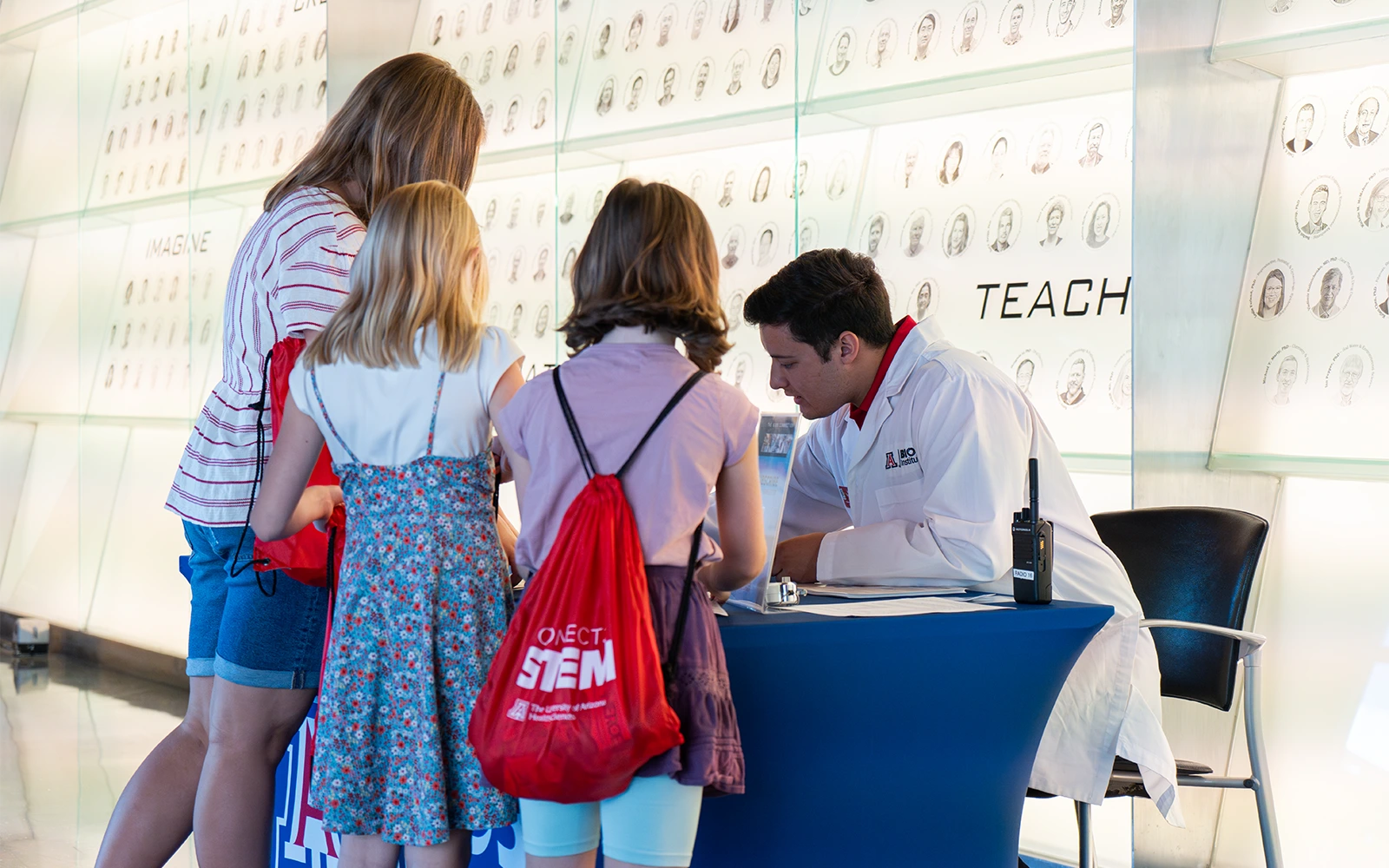 BIO5 staff member assisting a family with check in for the event