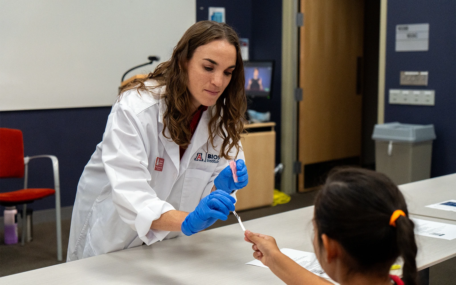 A BIO5 staff member distributing materials for the Sueprtasters experiment