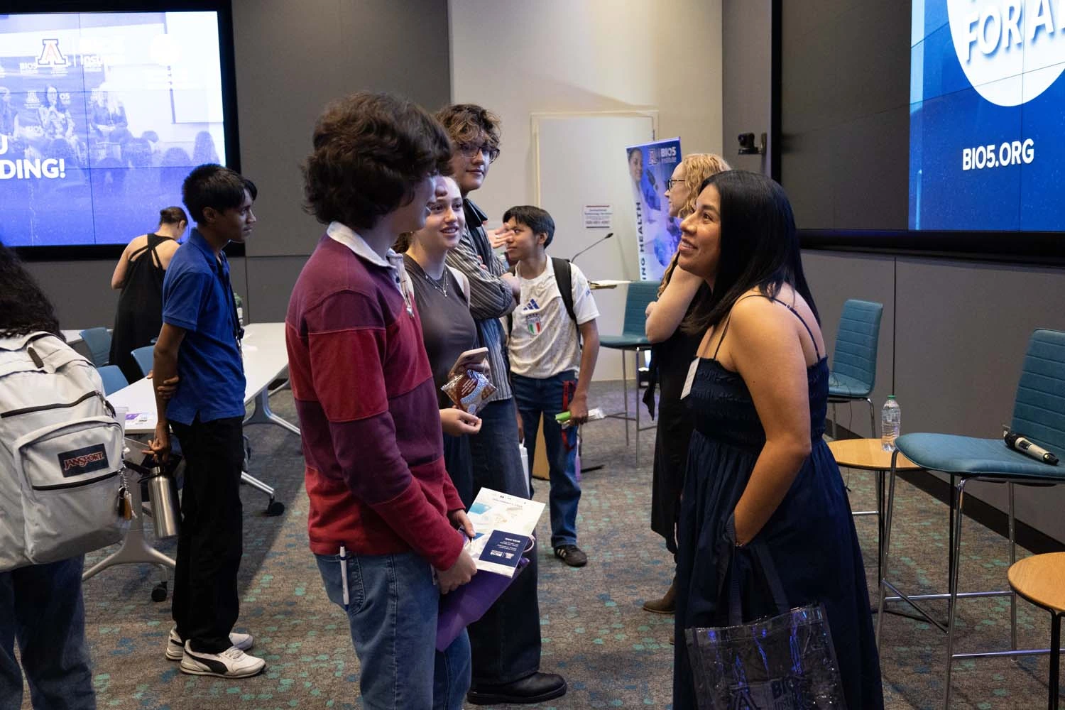 A group of people are engaged in conversation in a room.