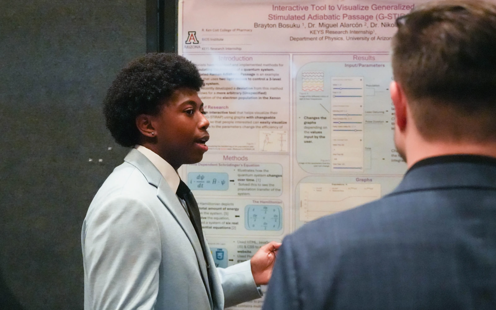 Brayton Bosuku showcases his research to an attendee of the AZBio Awards' Student Discovery Zone.