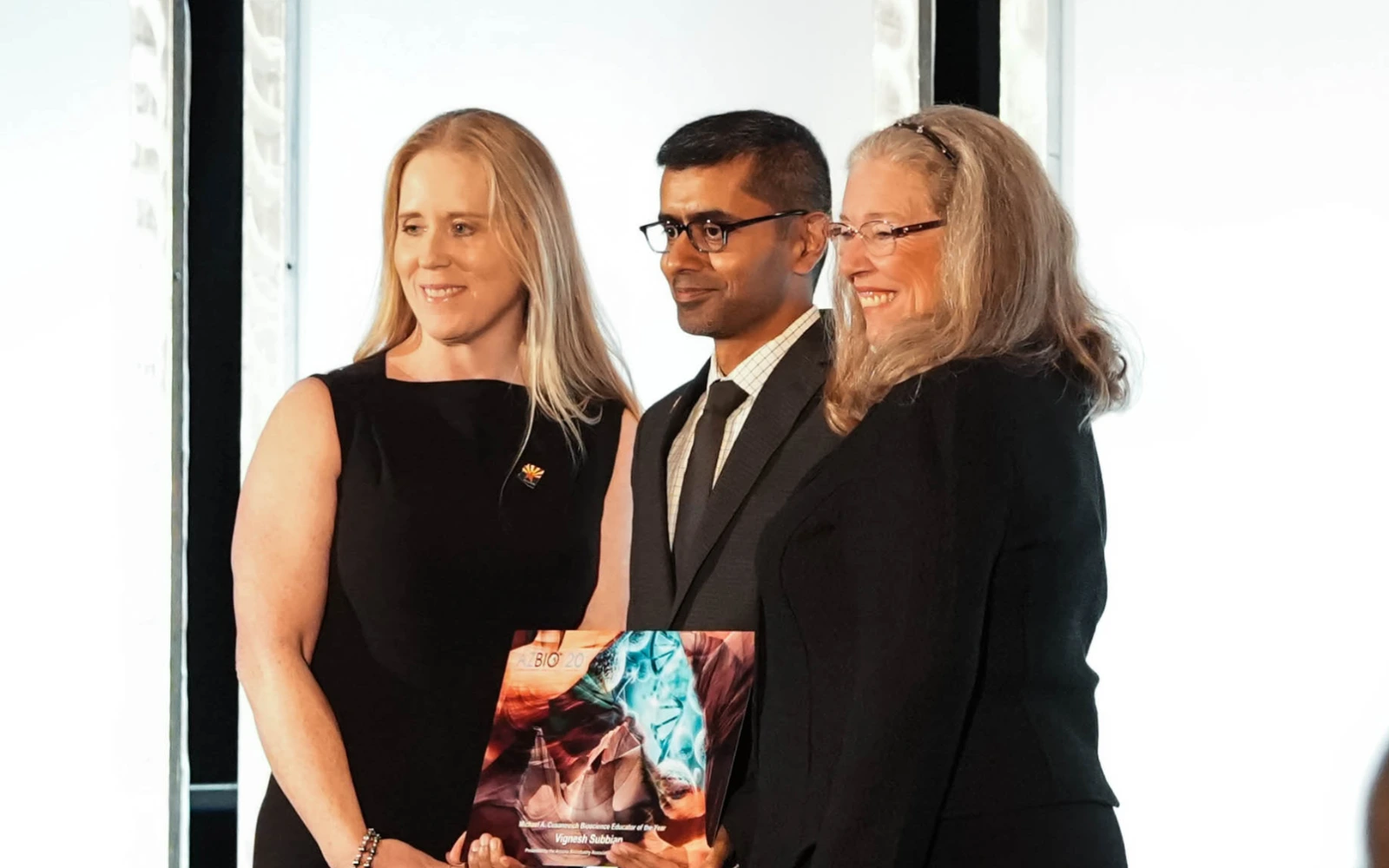 BIO5 Interim Director Vignesh Subbian receives the Michael A. Cusanovich Bioscience Educator of the Year award, presented by Kristen Swingle, President and Chief Operating Officer of the Critical Path Institute and BIO5 External Advisory Board member and Joan Koerber-Walker. 