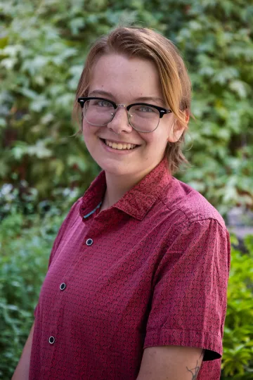 Student ambassador smiling with plants in background 