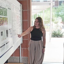 BIO5 Institute researcher points and describes her poster at an event