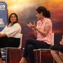 Panel of women speaking in front of artwork