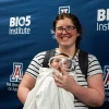 A mother and her baby who is dressed in a lab coat and safety goggles