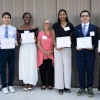 Student proudly holding certificates