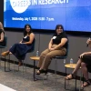 A panel discussion featuring four individuals seated in front of a large screen displaying the text "Careers in Research"