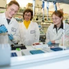 Group of people wearing lab coats and working in a lab