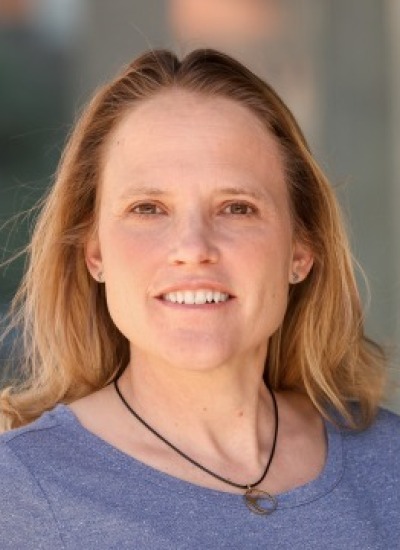 Headshot of Dr. Katy Prudic wearing a light blue shirt against a multicolored background