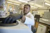 A scientist in a white lab coat working with equipment in a laboratory.